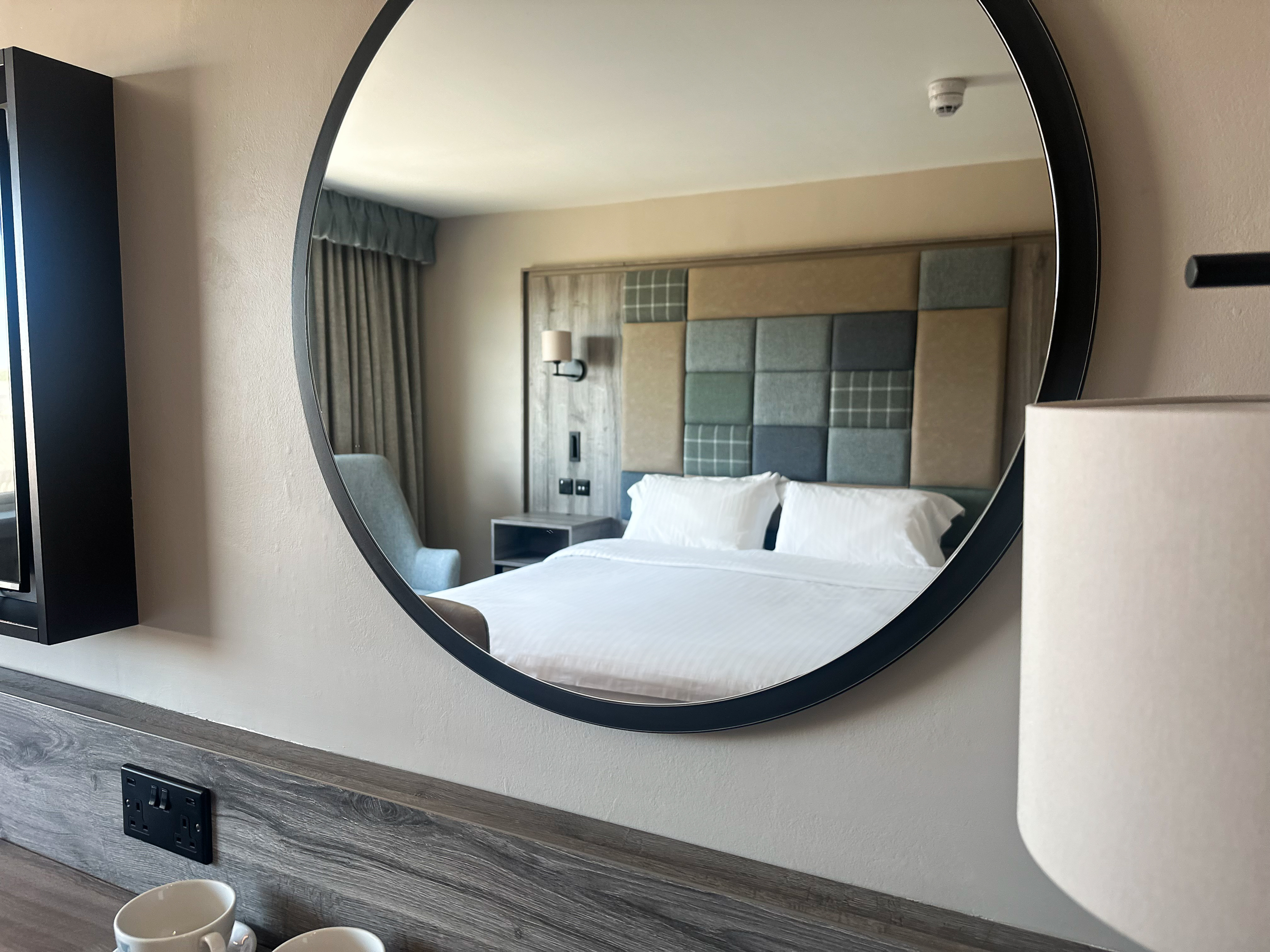 Executive double room at Cabarfeidh Hotel, with a large wall mounted mirror showing a large comfortable room.