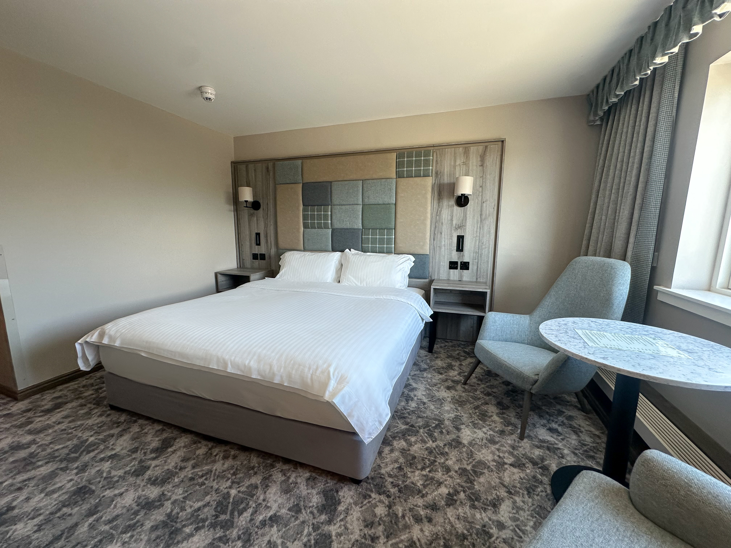 A welcoming light filled executive double room at Cabarfeidh Hotel with a comfortable bed.