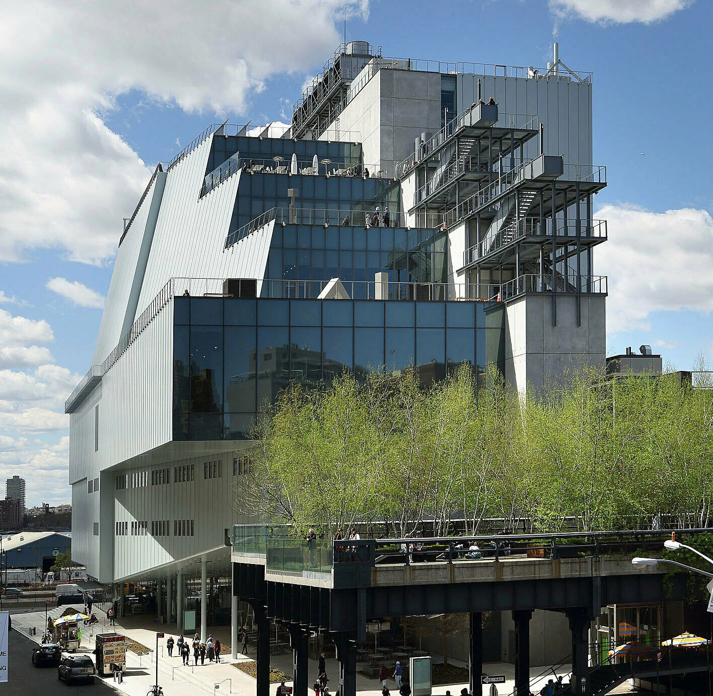 A large, modern building with a unique design and a tree on the roof.