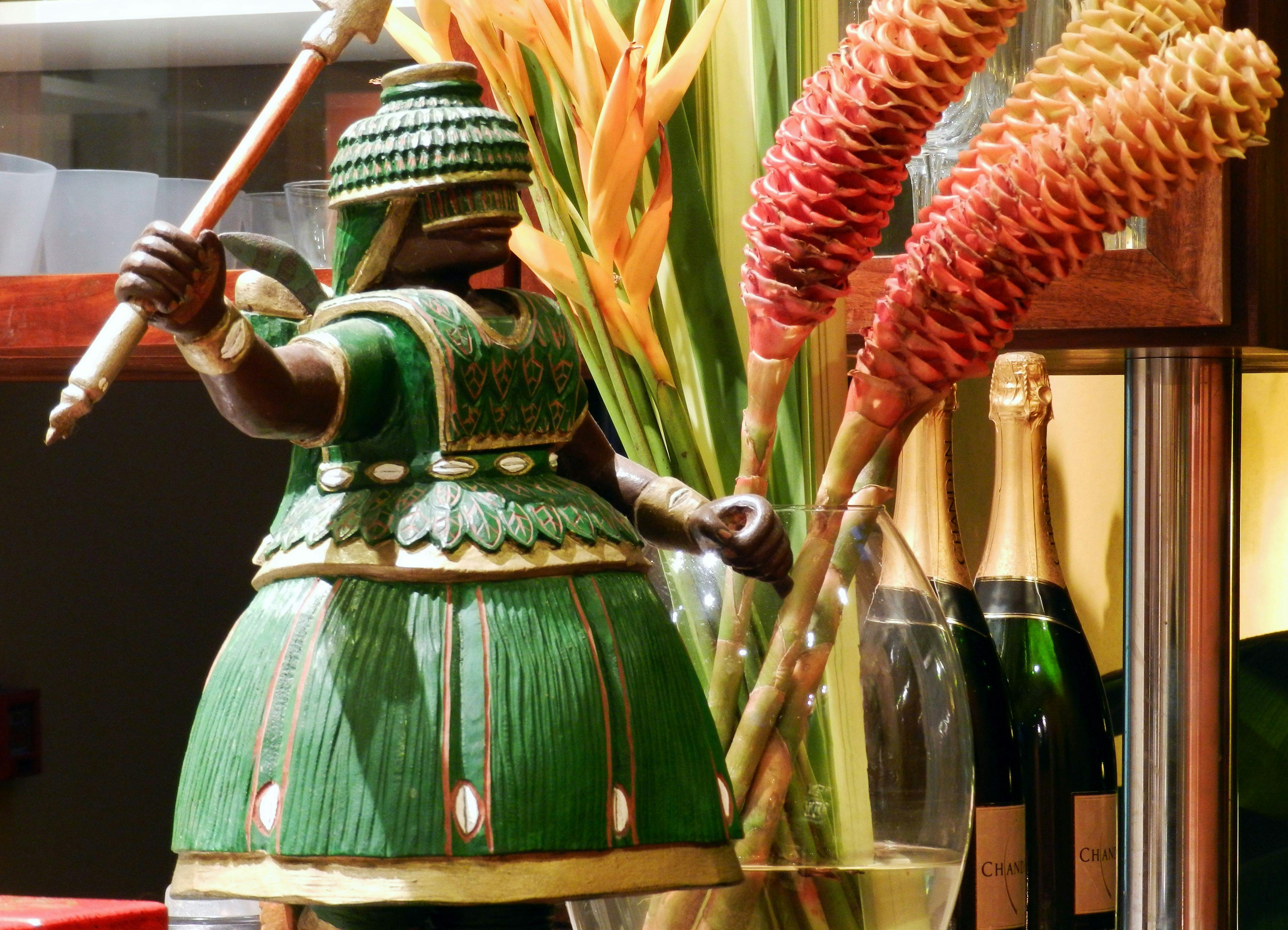 estátua em madeira maciça representando o orixá Iroko com vaso e flores