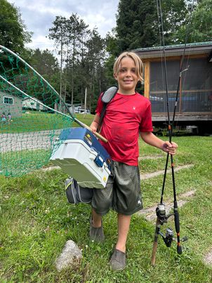 Kid-Friendly Fishing Cottages in Ontario - boy Holding a Fish at DaySpring Cottages