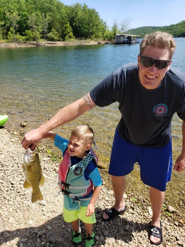 boy fishing with dad holding small mouth bass table rock lake fishing