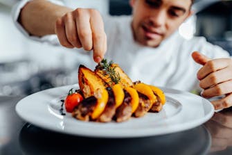 Chef cuisinier préparant un plat gastronomique avec soin