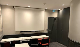 Salle de réunion de l'hôtel avec écran et tables