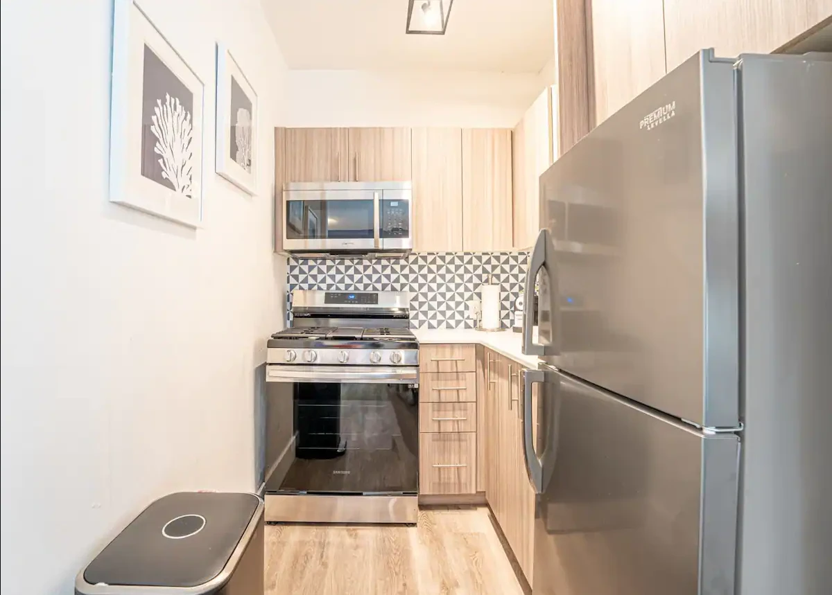 A kitchen with stainless steel appliances and light wood cabinets