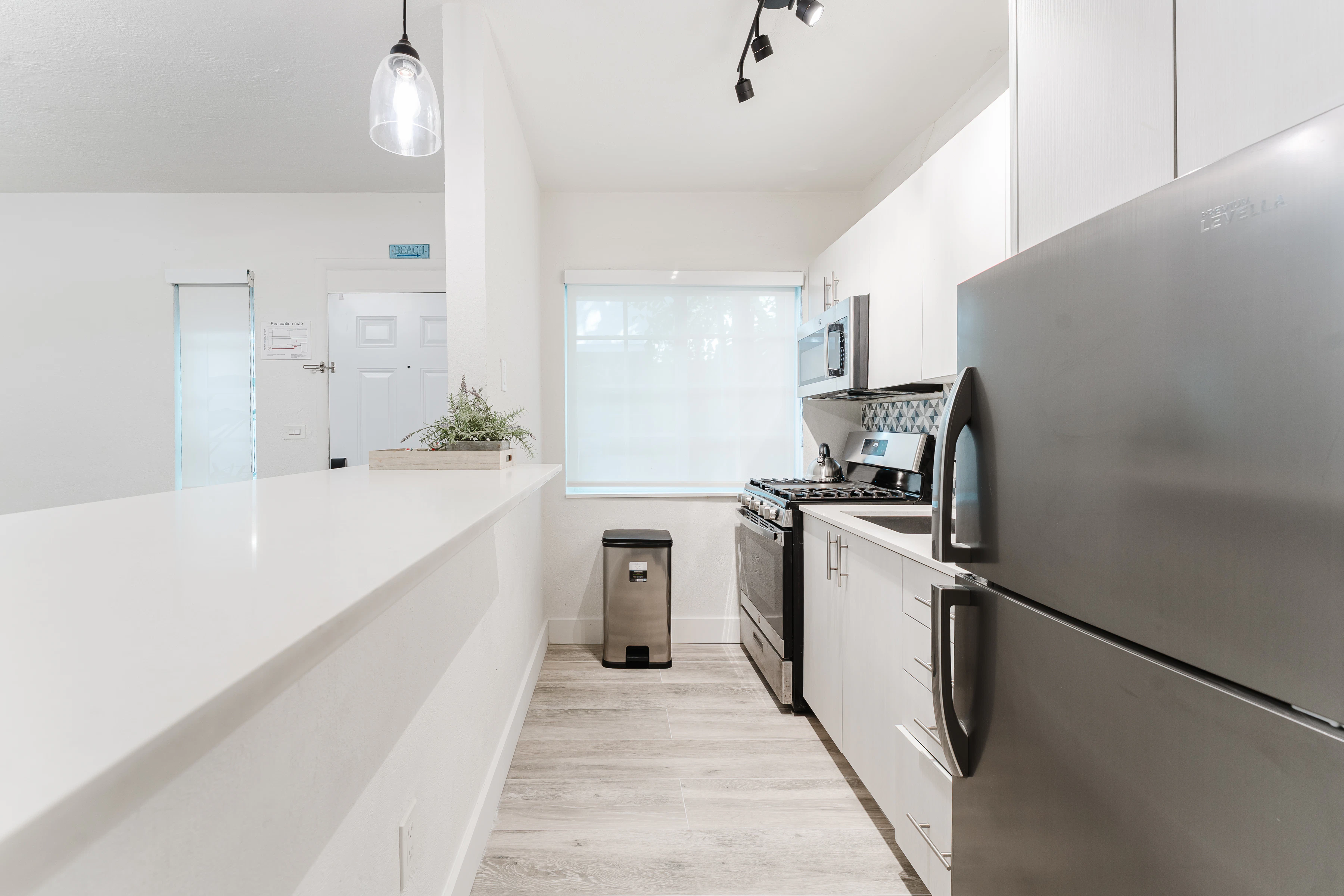 A modern kitchen with white cabinets and stainless steel appliances.