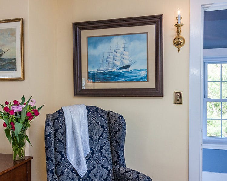 Sitting chair with beautiful sailing painting on the wall.