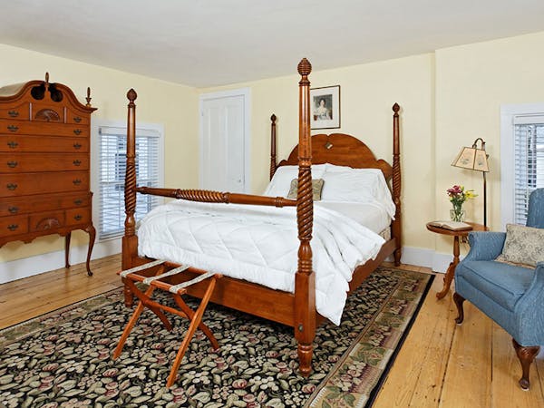 Four-post bed with beautiful area rug.