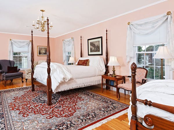 Four-post bed with beautiful area rug shown.