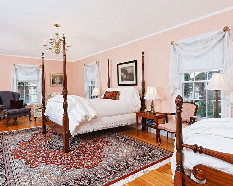 Four-post bed with beautiful area rug shown.
