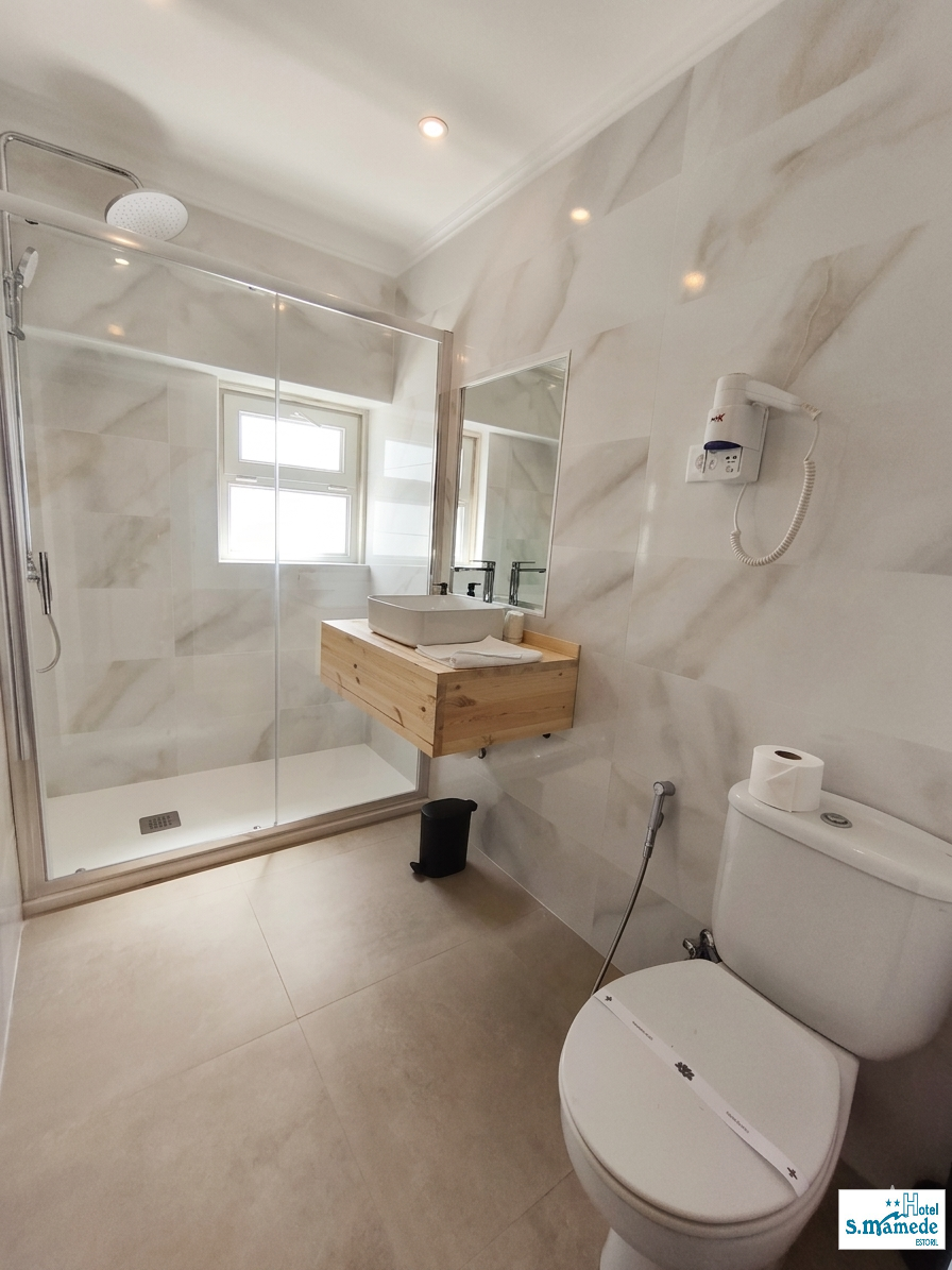 Modern ensuite bathroom with walk-in shower in renovated Estoril room