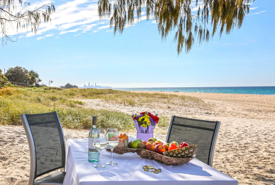 Picnic table set with fruit on the sand at Tugun Beach