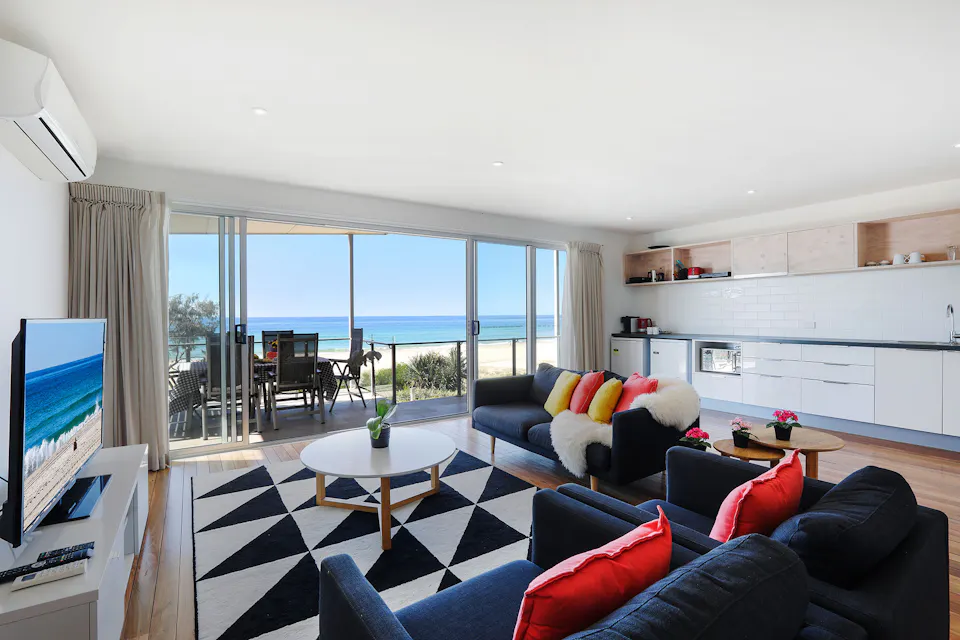Living room with ocean views through the sliding doors at Sandbox Apartments