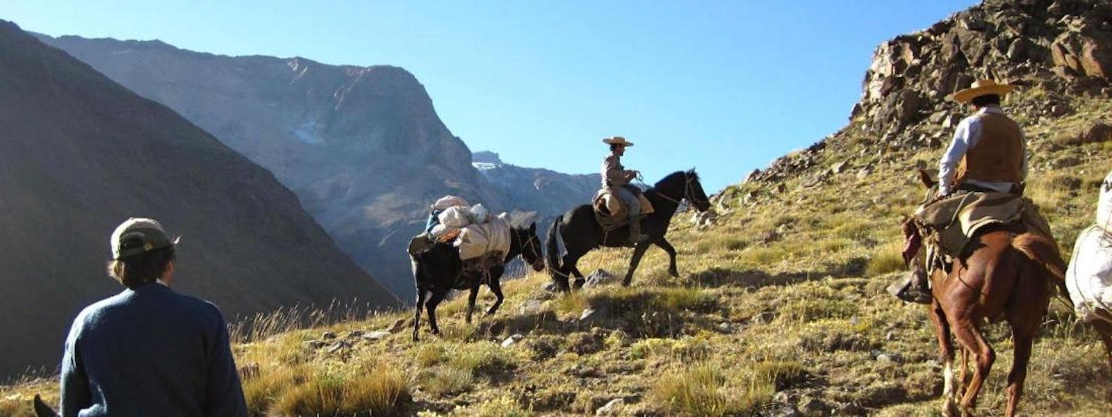 Man on a horse with a second horse carrying his trekking equipment.