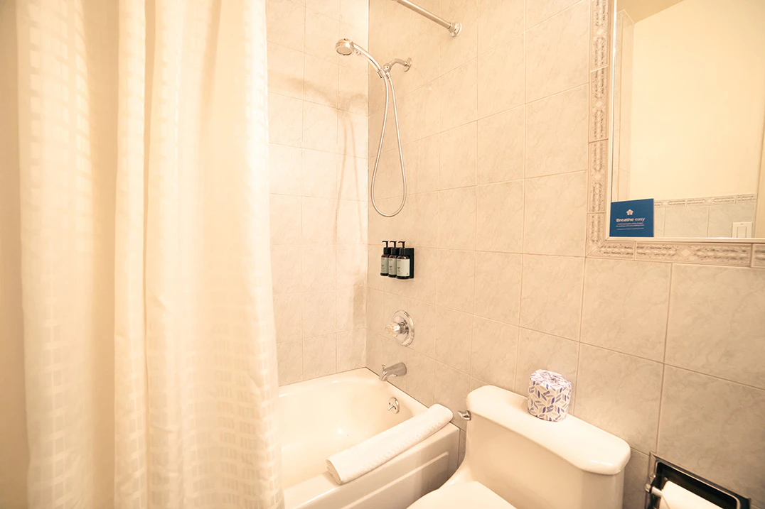 A clean bathroom with a bathtub, toilet, and shower.