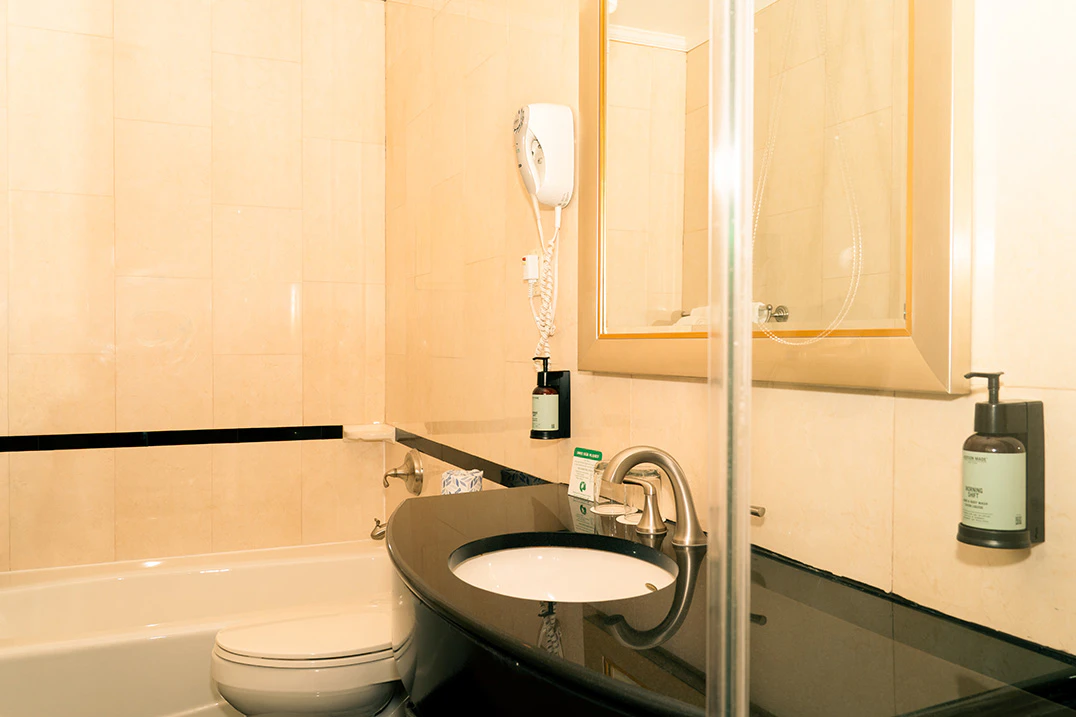 A bathroom with a toilet, sink, mirror, shower, and bathtub.