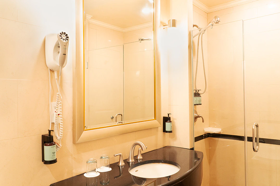 A bathroom with a shower, sink, and mirror