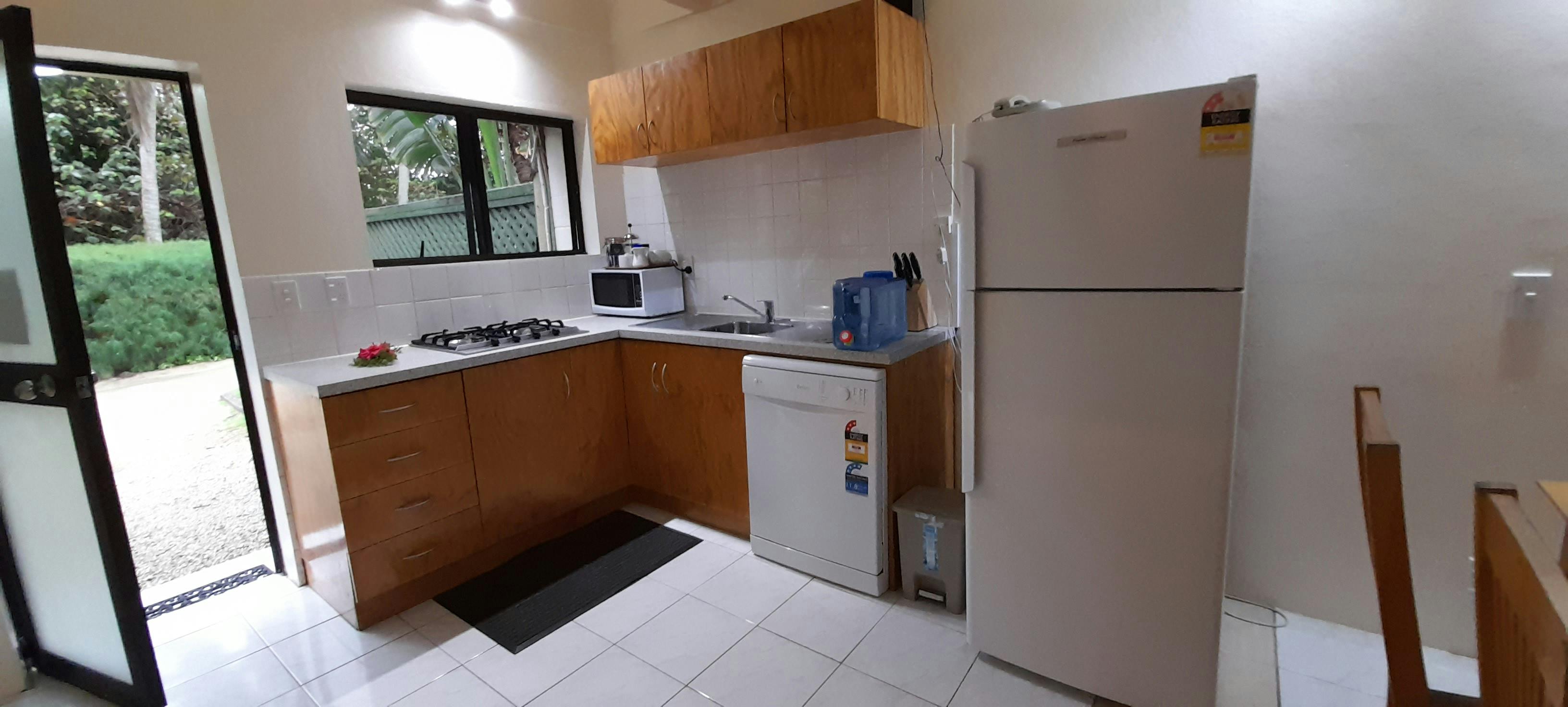 3 bedroom kitchen with Fridge/freezer, dishwasher, 4 burner stove, drinking bottle.
