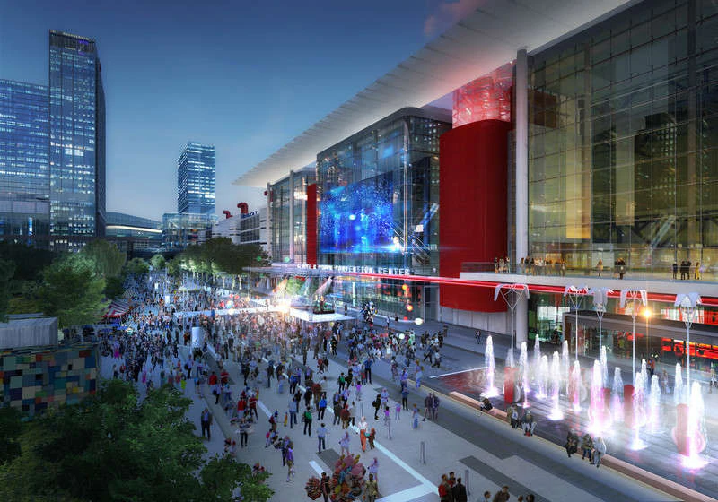 A large building with a glass facade and a fountain in front of it, surrounded by a crowd of people in a city setting.