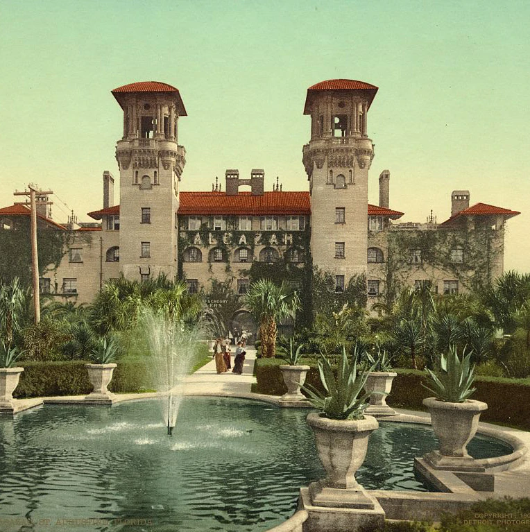A large hotel with two towers and a fountain in front