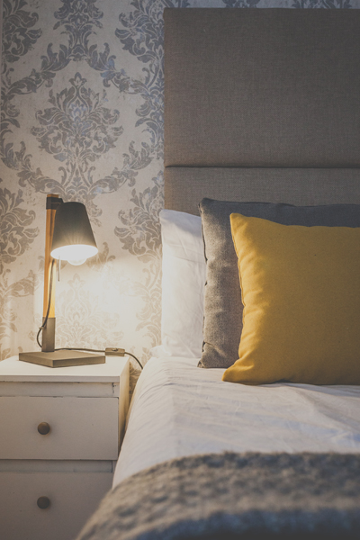 Pillows are on the bed of a beautifully decorated double room with ensuite, a table lamp creates a cozy atmosphere