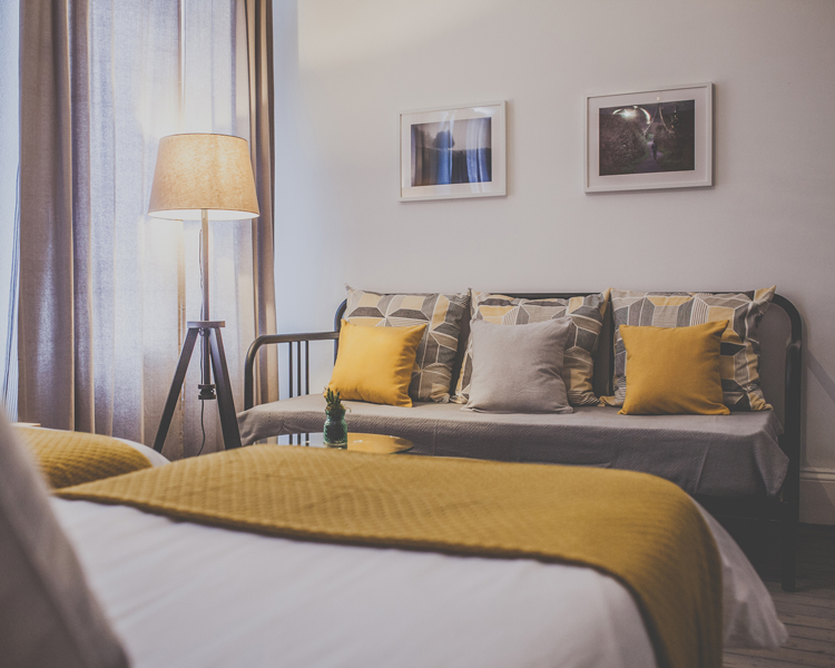 A stylish and unique decorated triple room with cozy lightning features and a sleeping couch