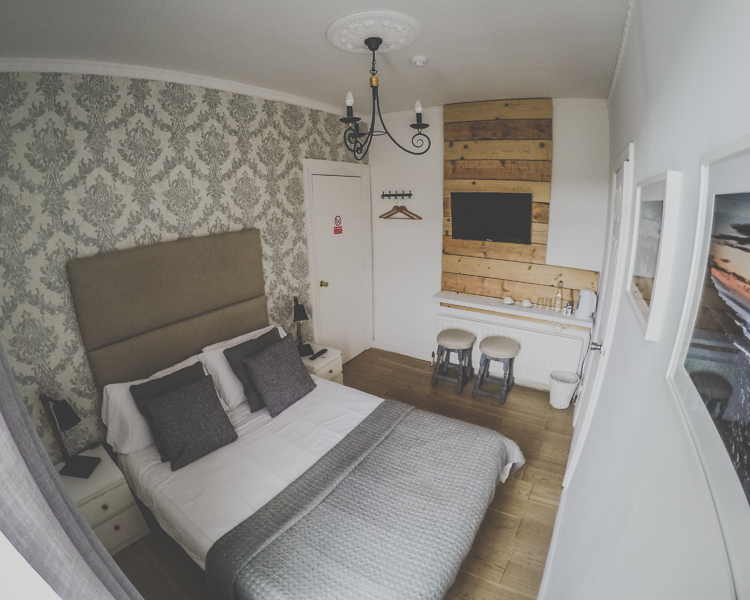 A beautifully decorated double room with ensuite in a cozy atmosphere. Two stools standing underneath the TV