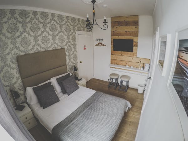 A beautifully decorated double room with ensuite in a cozy atmosphere. Two stools standing underneath the TV
