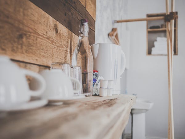 Coffee, tea and a bottle of water standing on a wooden shelve