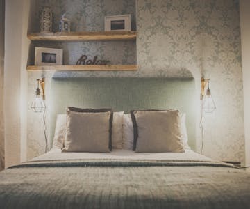 Pillows are on the bed of a beautifully decorated double room with ensuite, table lamps creating a cozy atmosphere