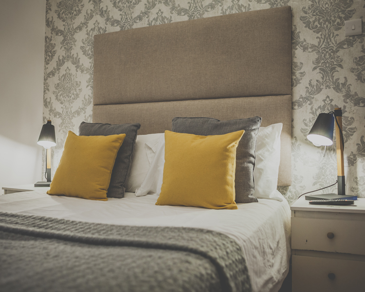 Pillows are on the bed of a beautifully decorated double room with ensuite in a cozy atmosphere