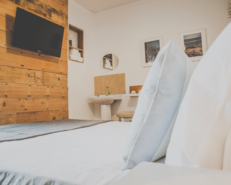 A double room decorated in a maritime style coming along with a TV, sink, hangers and shabby chic furniture