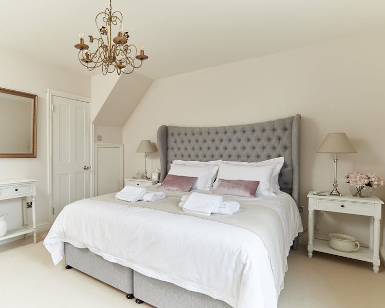 View of Master bedroom Hypnos Bed with beautiful, decorative headboard, crisp white bed linen and throw.