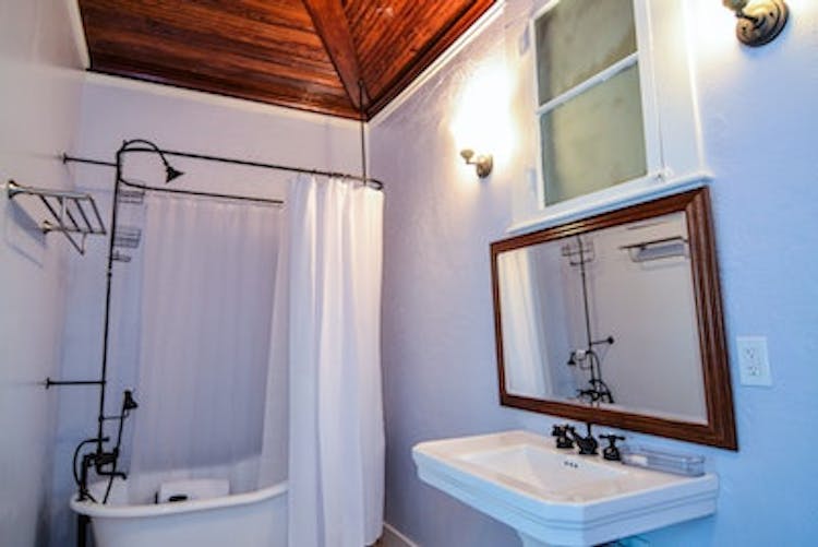 Caribbean bathroom; pedestal sink, toilet, and clawfoot tub with shower. Shared