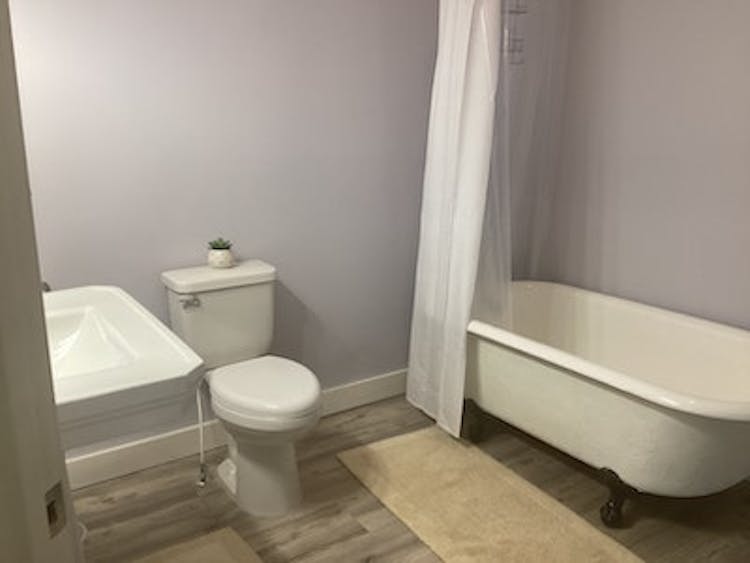 European King bathroom: pedestal sink, toilet, and clawfoot tub with shower.