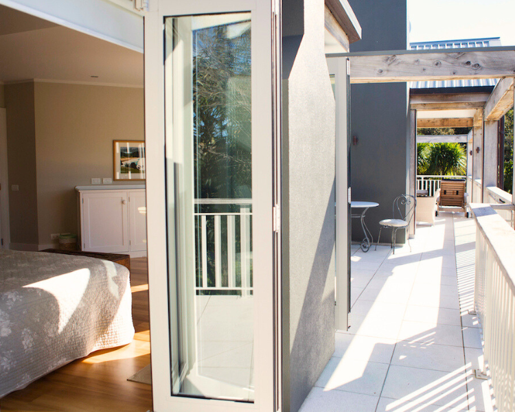 Private outdoor deck with bi-fold doors opening to the sunny bedrooms - Estuary Terrace Suite, 970 Lonely Bay Lodge