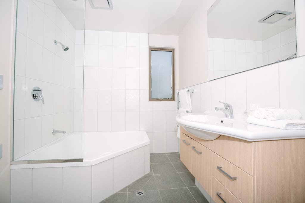 Relaxing and serene bathroom in the 1 bedroom apartment at Oakridge Resort, with a deep soaking tub, fluffy towels, and all t