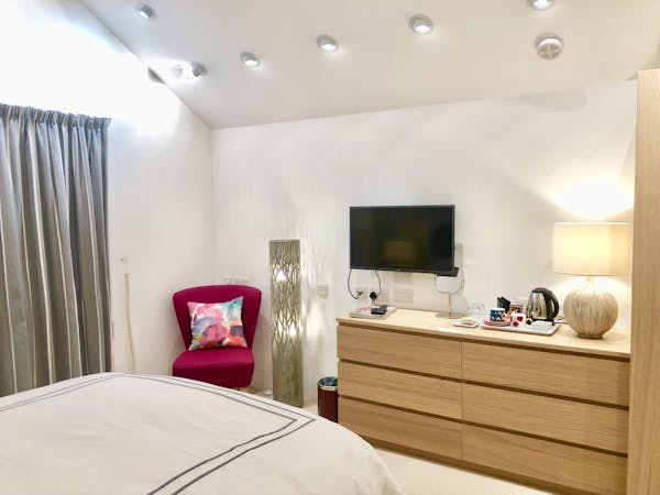 Bedroom 2 showing showing TV area with vaulted ceiling, down lights and designer standard lamp