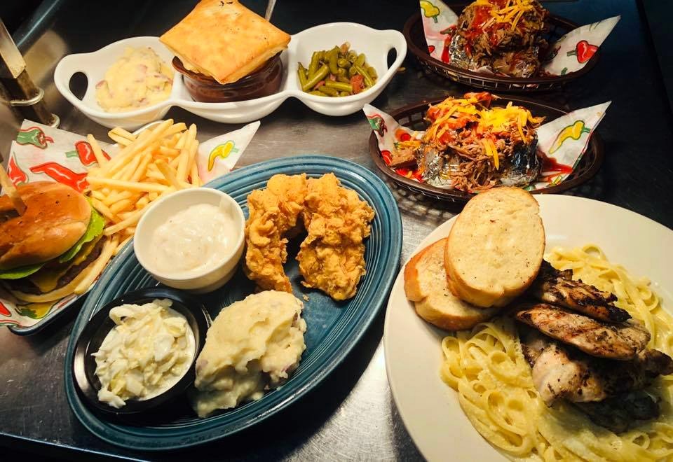 Several plates of southern cooked food including fried chicken