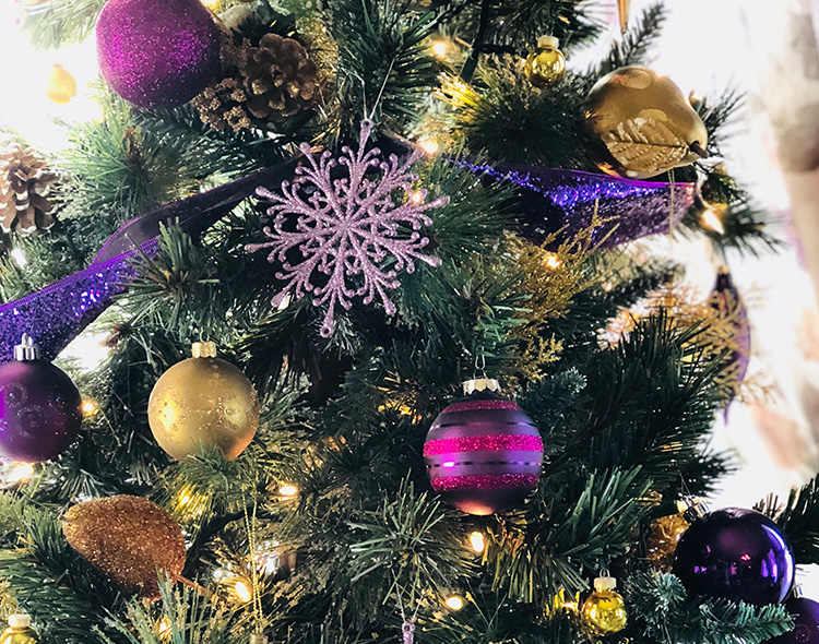 Close up photo of a green, purple and gold Christmas tree