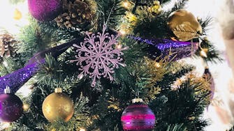 Close up photo of a green, purple and gold Christmas tree