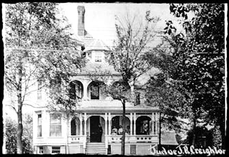1890's photo of The Victorian on Main with people standing on the porch