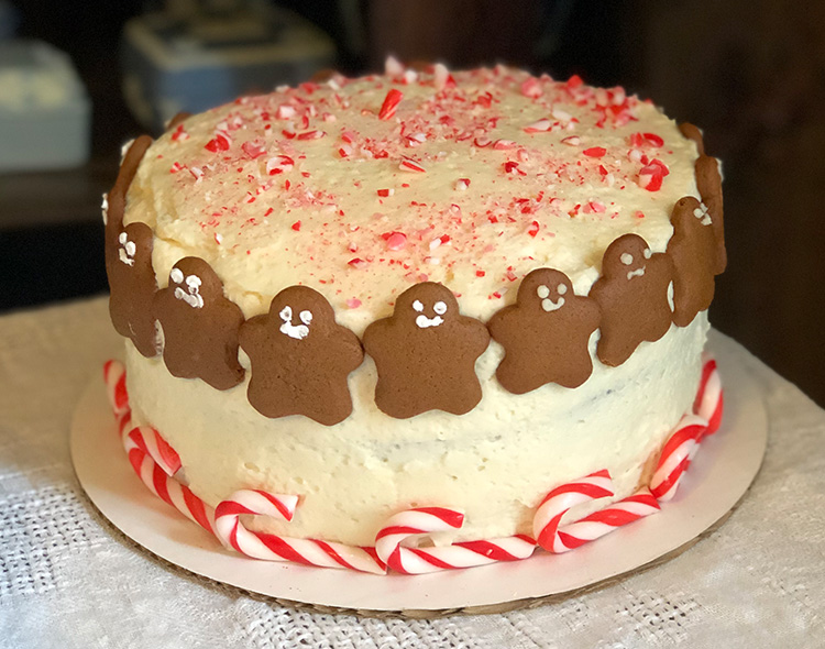 Holiday cake decorated with mini gingerbread men, peppermint crumble topping and candy canes