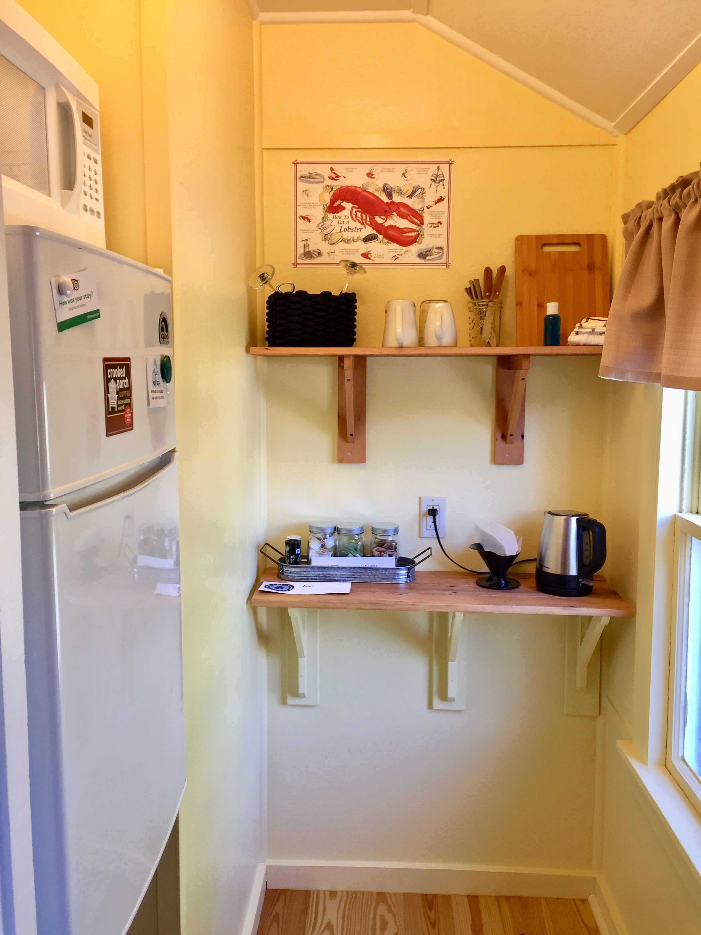 A small kitchen area with a refrigerator, microwave, and kitchenette.