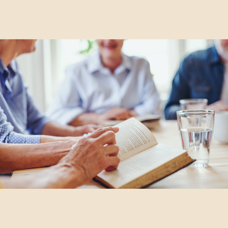People around a table reading together.