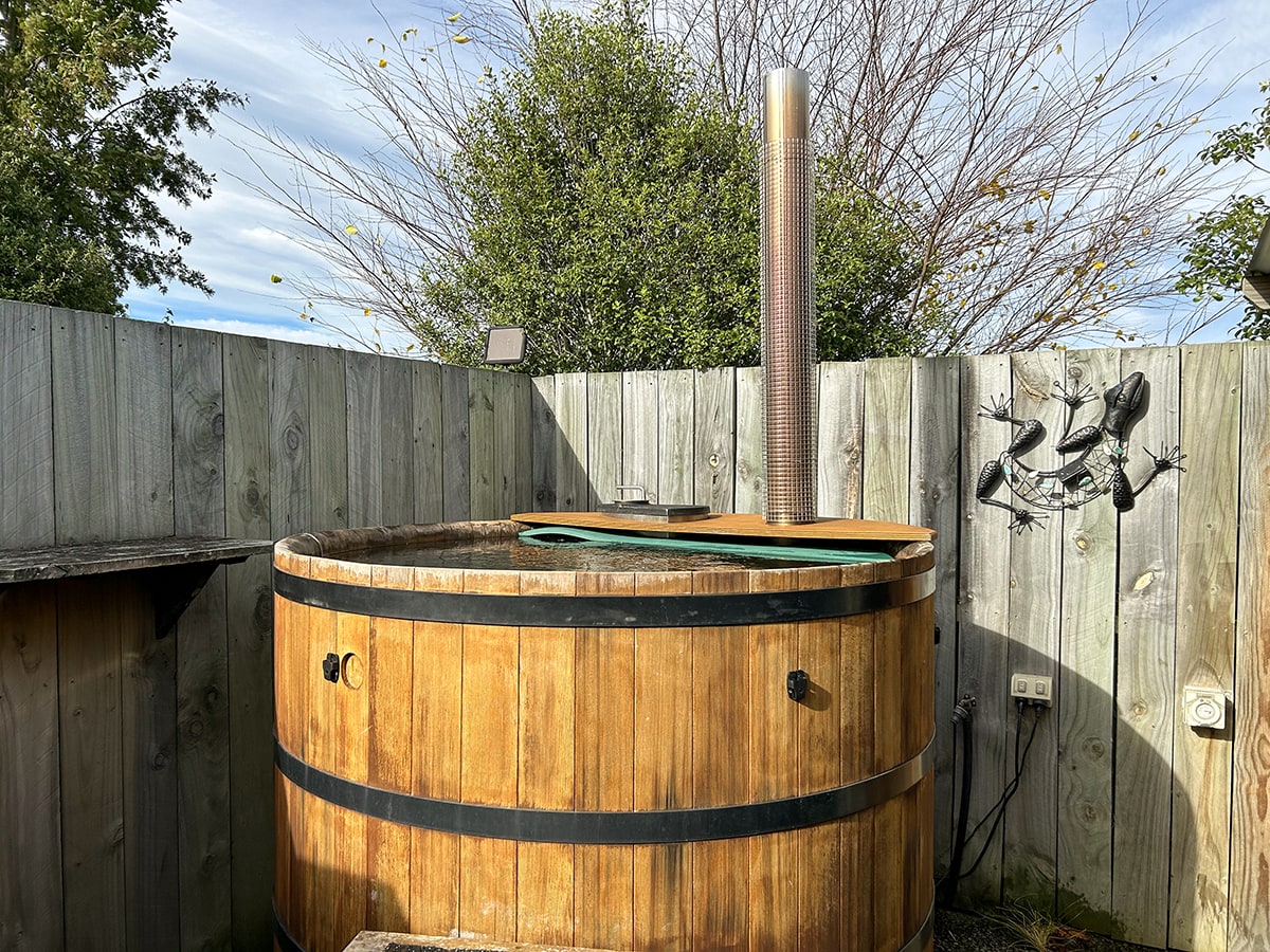 A hot tub with privacy screen and native plantings at Musterer's Accommodation, Fairlie.