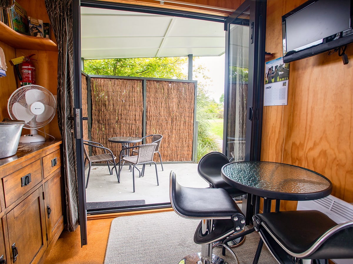 A rustic studio cabin and outdoor dining area at Musterer's Accommodation, Fairlie.