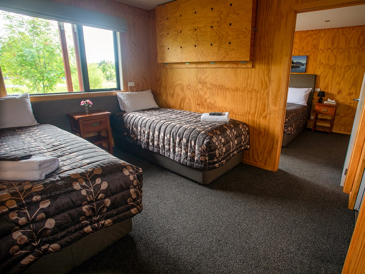 A timber bedroom with two beds at Musterer's Accommodation, Fairlie.