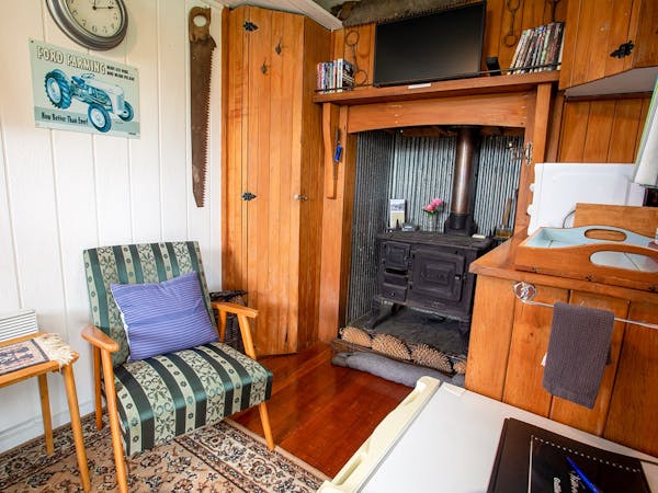 A rustic vintage living area with coal range at Musterer's Accommodation, Fairlie.