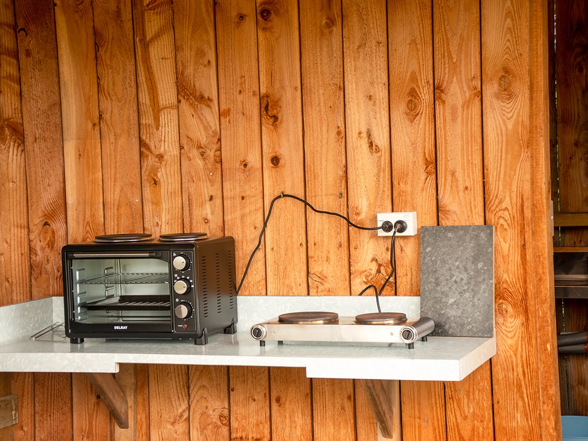 A kitchenette bench with rustic timber wall at Musterer's Accommodation, Fairlie.